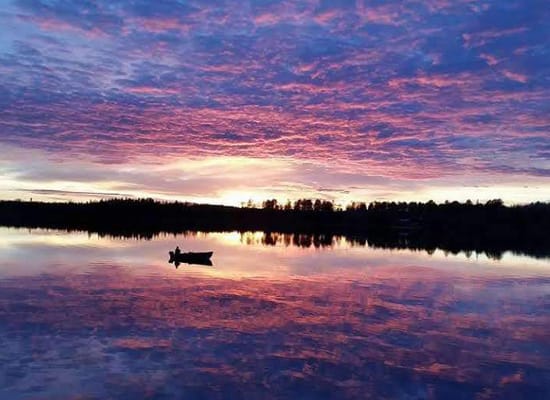 Image of a lake at sunset with a boater. Links to Lake Life.